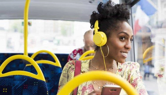 Portrait of woman relaxing on a bus wearing headphones