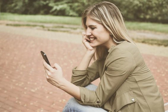 Caucasian woman using smart phone outdoor.