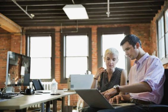 Entrepreneurs working on laptop in creative office space