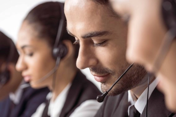 Close up view of call center operators in headsets working together