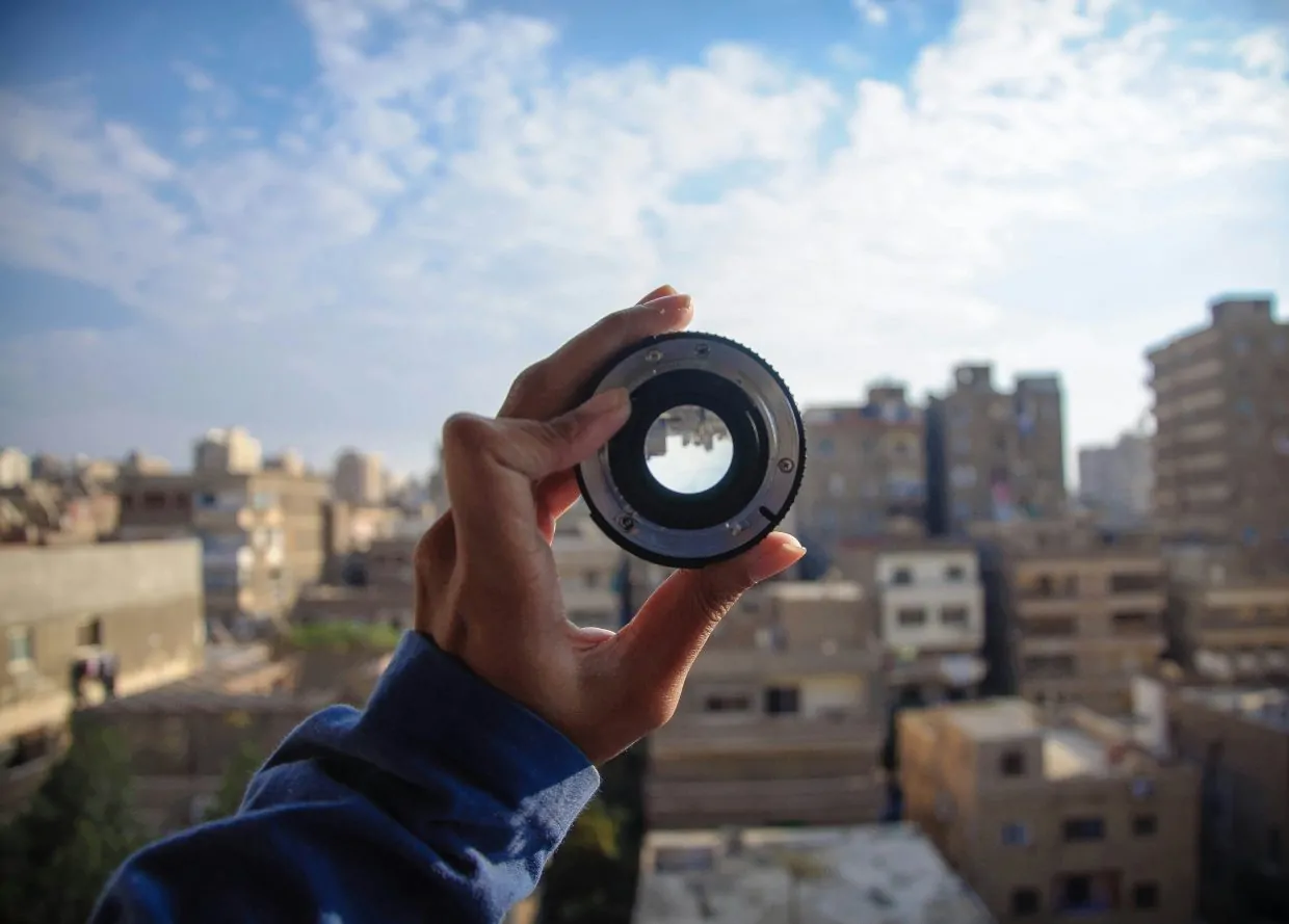 Cropped hand holding camera lens