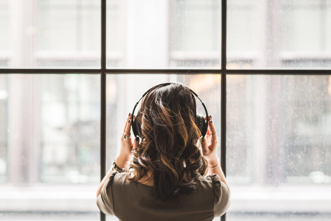 Canva   woman listening on headphones