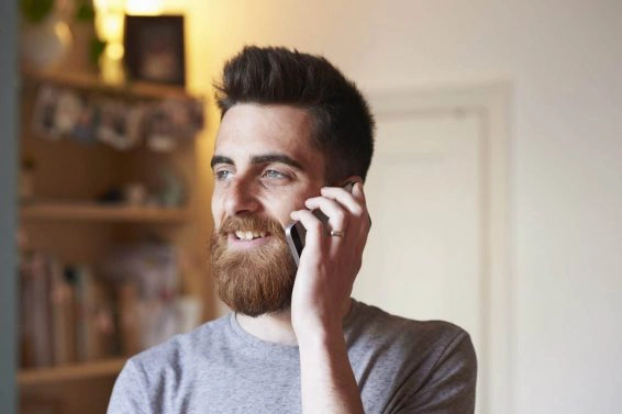 Hipster man using a smart phone in his living room