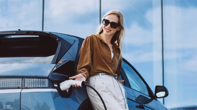 Happy woman charging her electric car