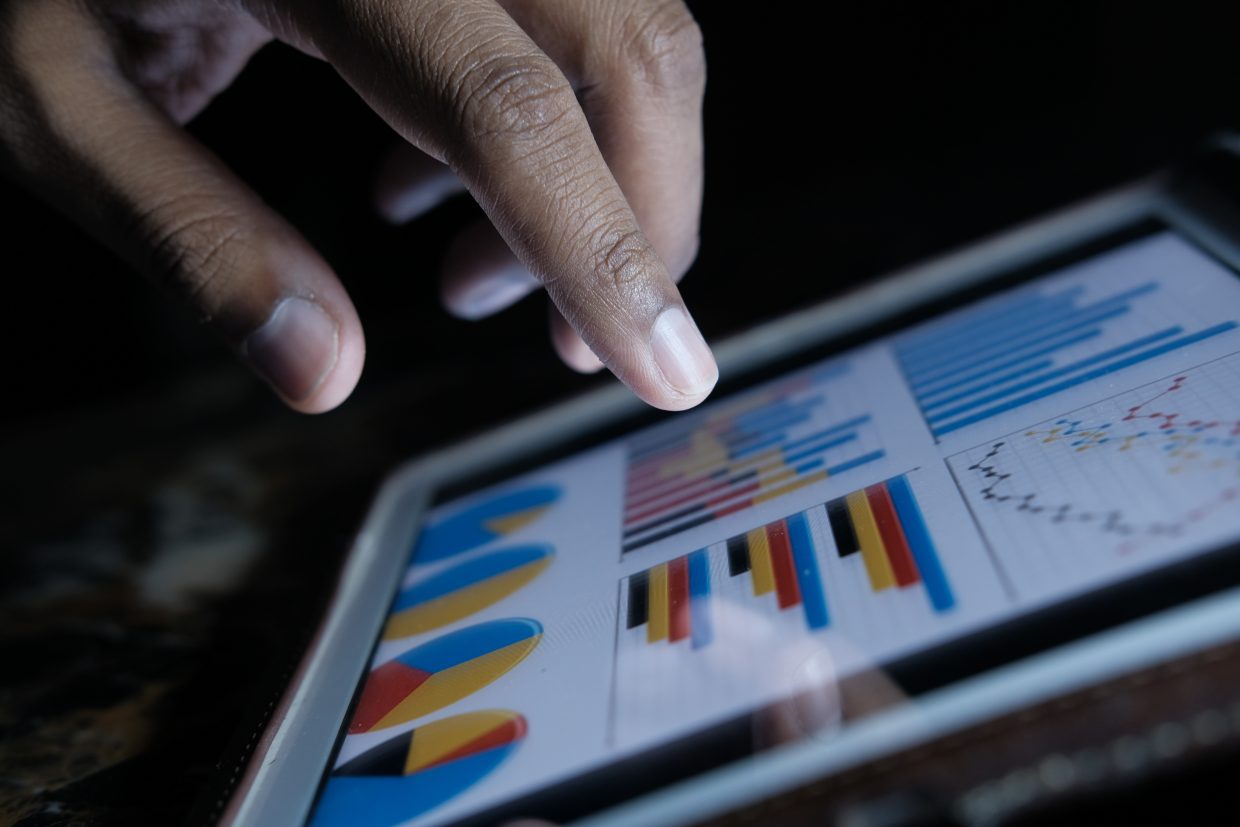 finger pointing stock market trend on digital tablet