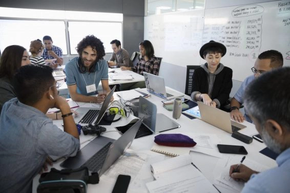 Millennial hackers working at laptops during hackathon