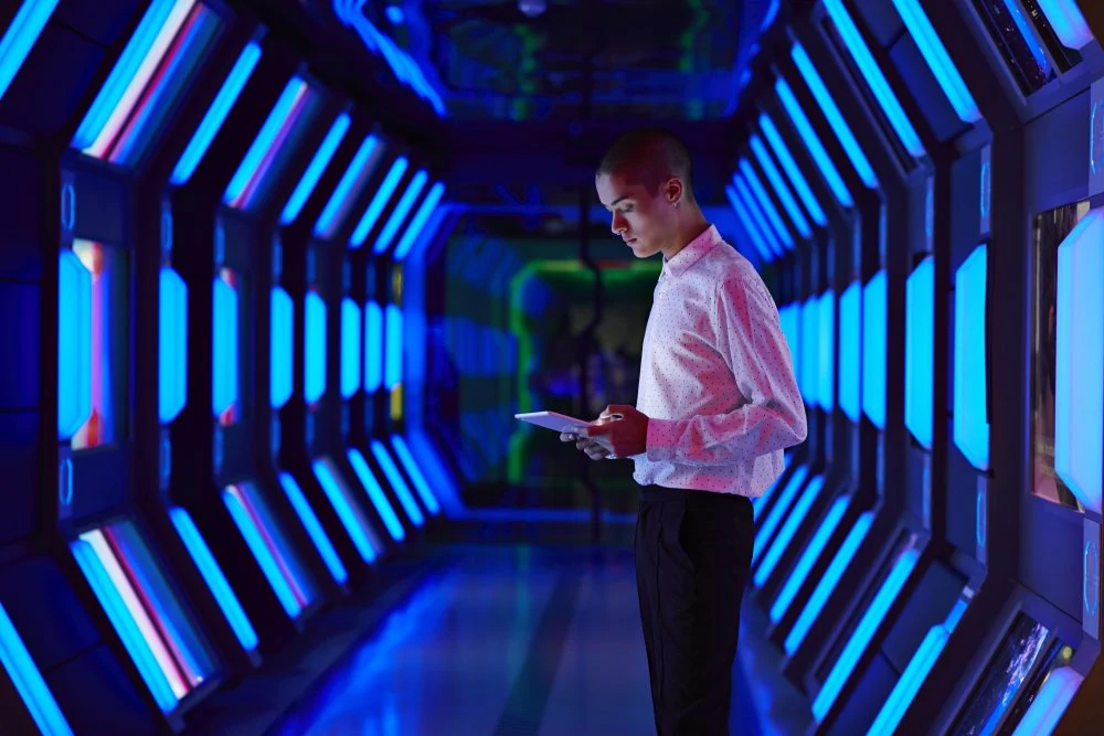 Young businessman looking at digital tablet in spaceship like corridor