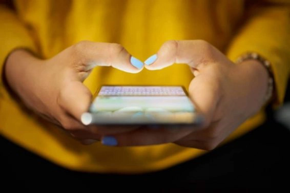 Woman typing phone message on social network at night