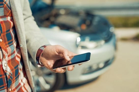 Man using smartphone after traffic accident