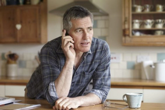 Man using phone in kitchen
