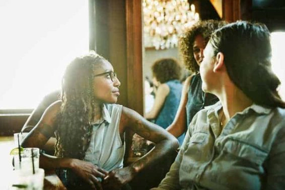 Female friends in discussion while hanging out in bar