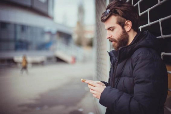 Bearded man using phone outdoors