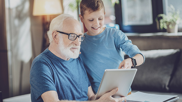 Attentive pensioner looking at screen of tablet