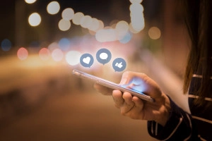 Woman hands using mobile smartphone in the street with icon soci