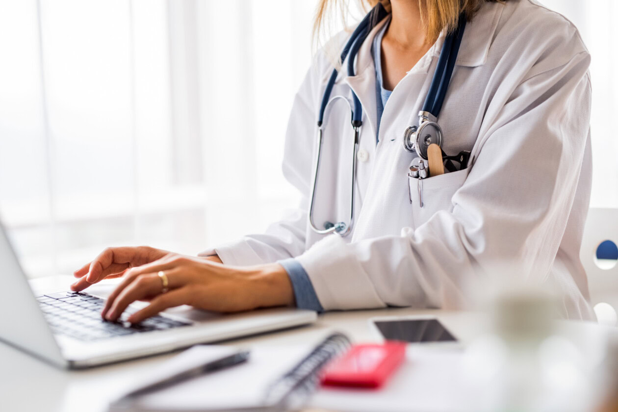 Female doctor with laptop working at the office desk.
