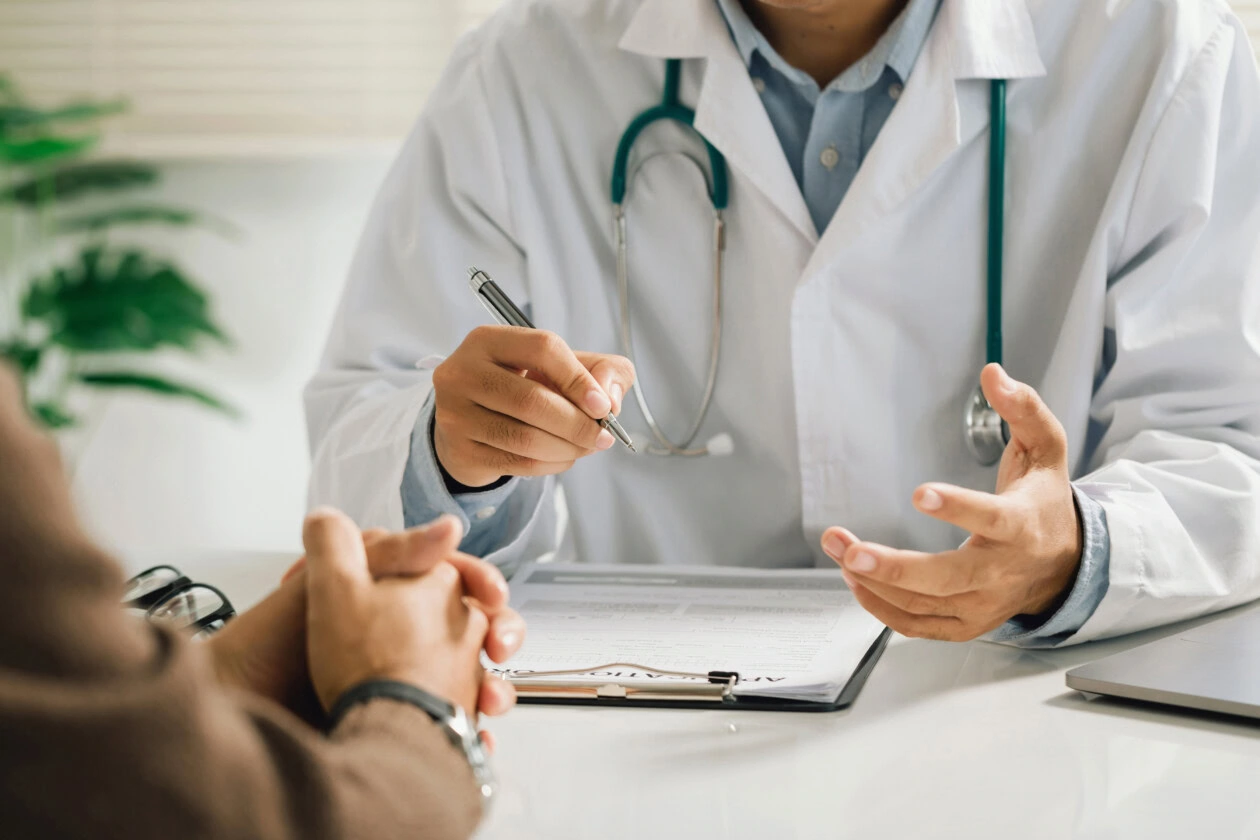 A professional physician in a white medical uniform talks to dis