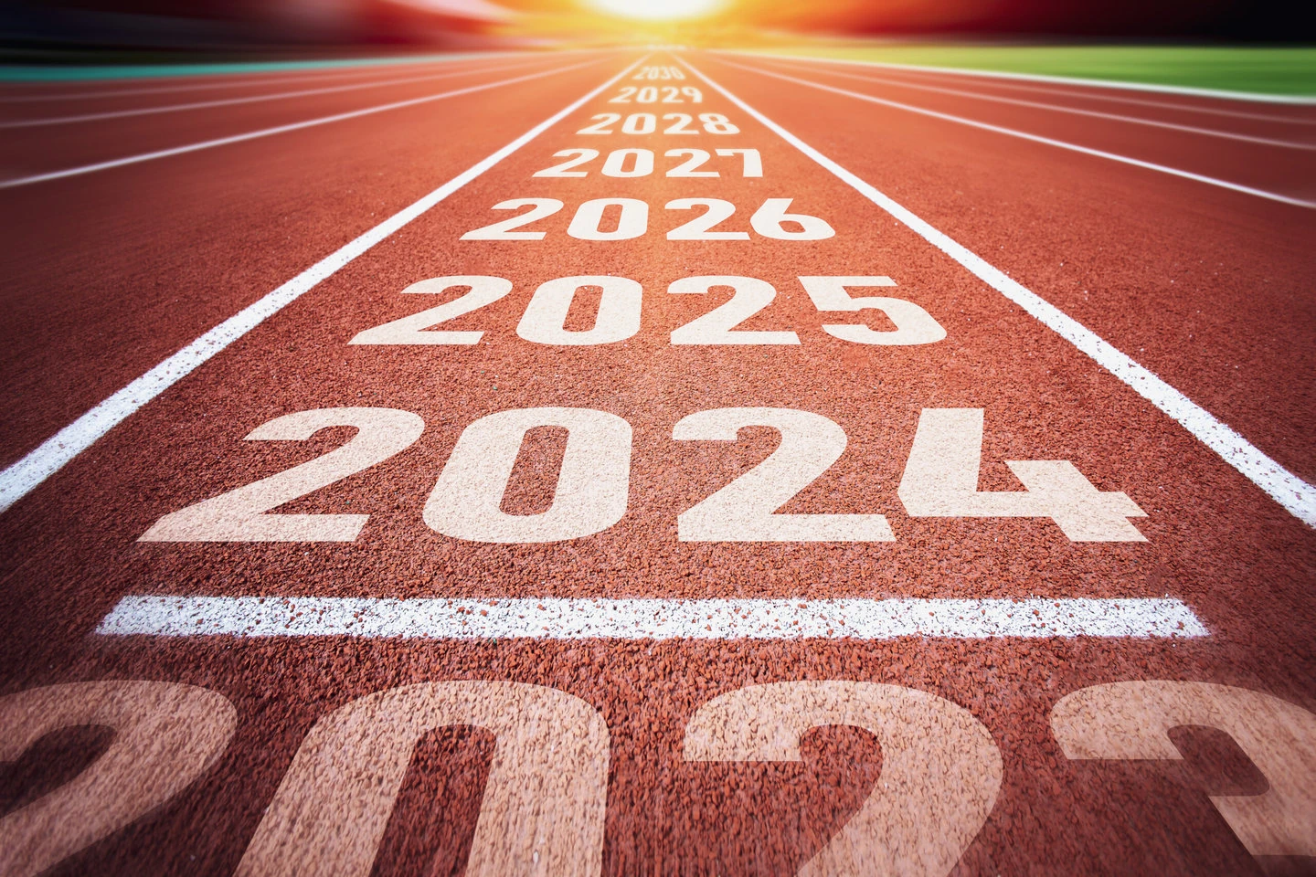 Start of new year. changes of year 2024, 2025, 2026 on running track. concept of new ideas starting in new year, planning along with setting objectives to set kpi goals for success in life.