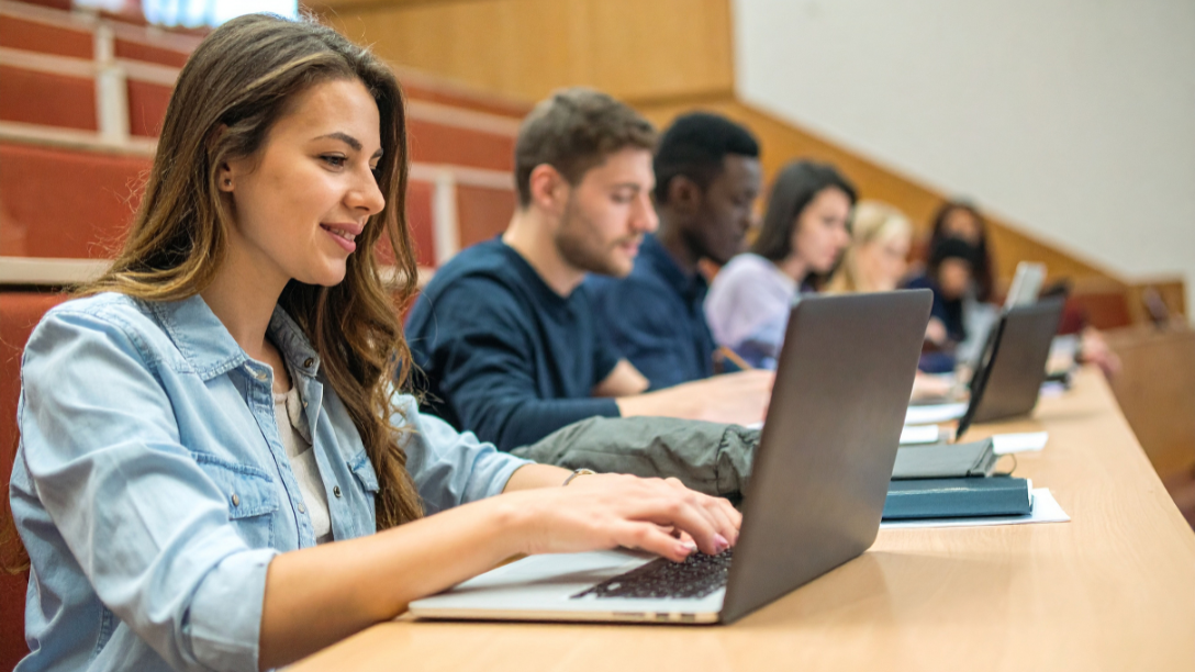 University students sitting in class using their laptops to take notes