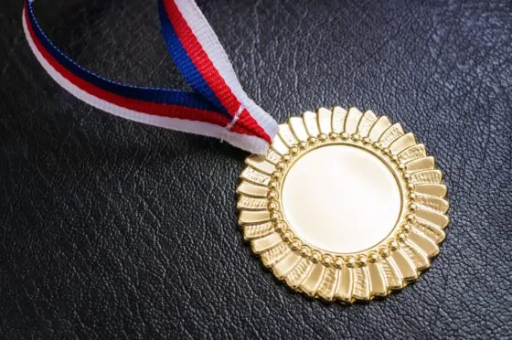 Gold medal   award for a winner on black background.