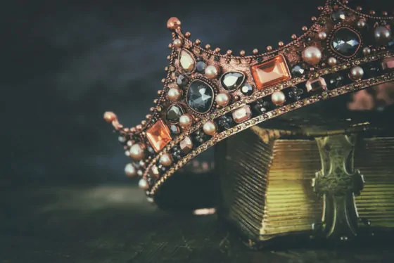 Low key image of beautiful queen/king crown on old book