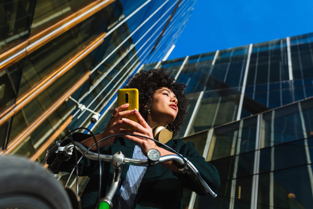 Beauty woman in a bike using a mobile with distracted look