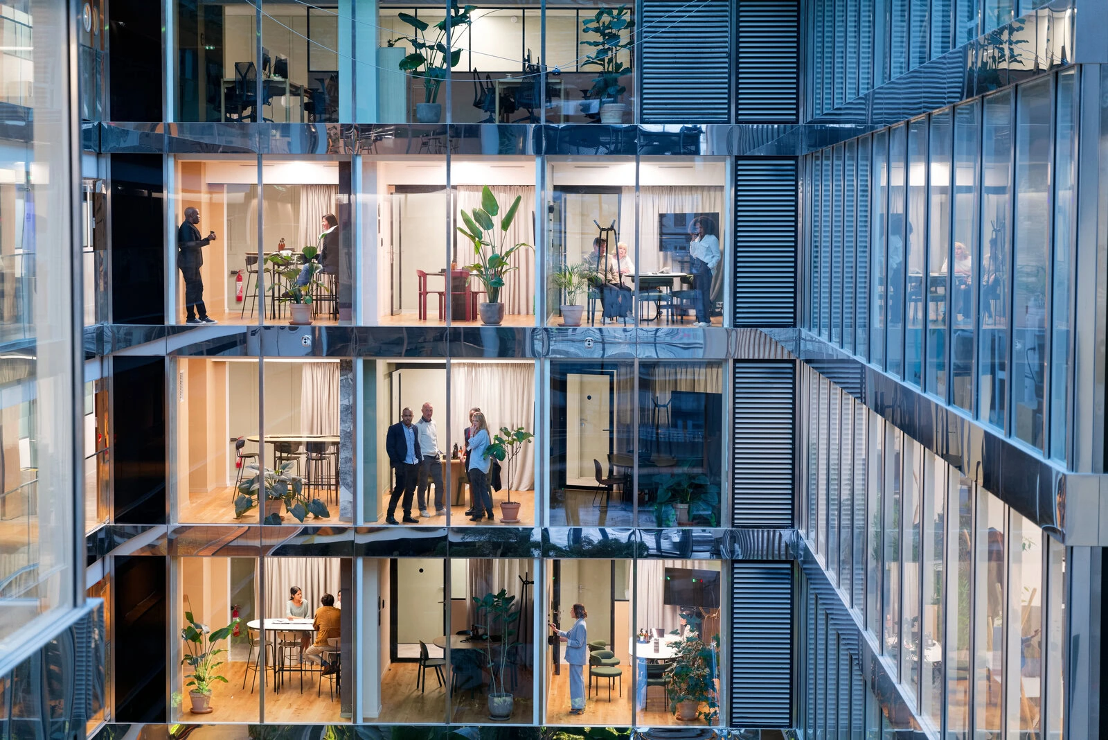 Businessmen and businesswomen working in several offices and on several floors in a modern building of a company