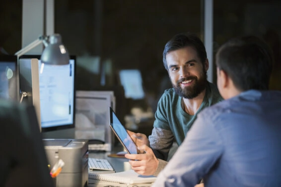 Businessmen with digital tablet working late in office