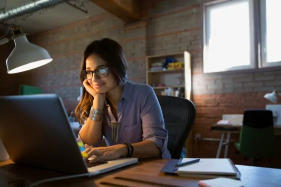 Female designer using laptop at desk in office