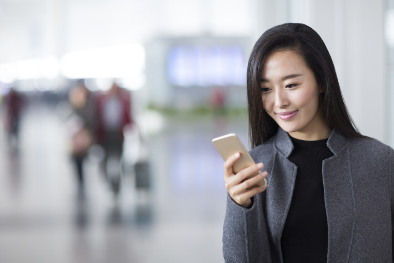 Businesswoman using smart phone in airport