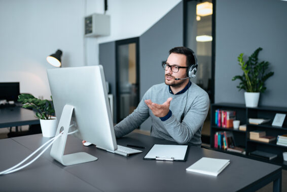 Handsome customer support operator explaining to his customer how to resolve problem that he has.