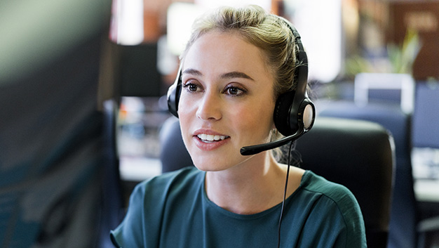 Smiling businesswoman wearing headset at office