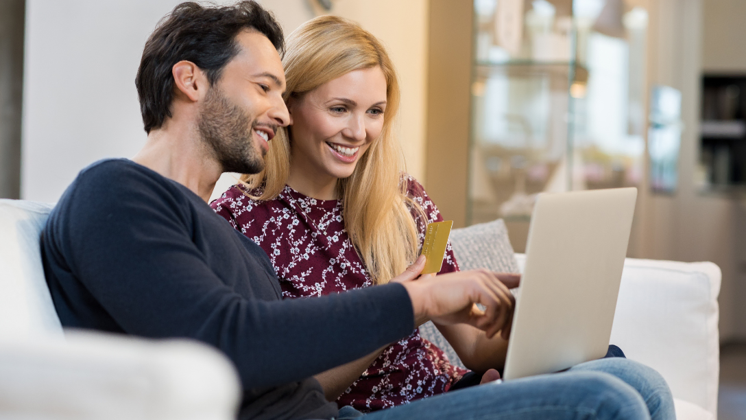 Happy couple banking together online.