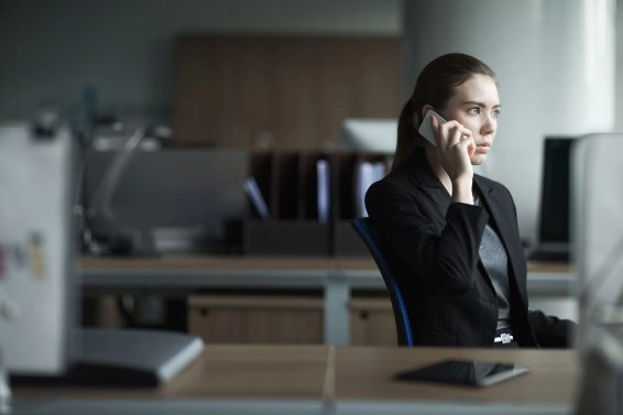 Young woman using cell phone in business office