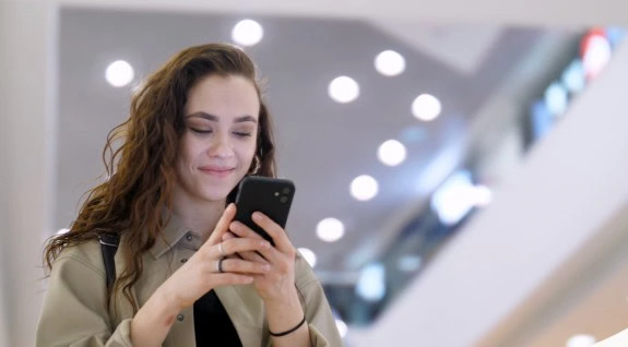 Happy woman banking on her mobile phone.