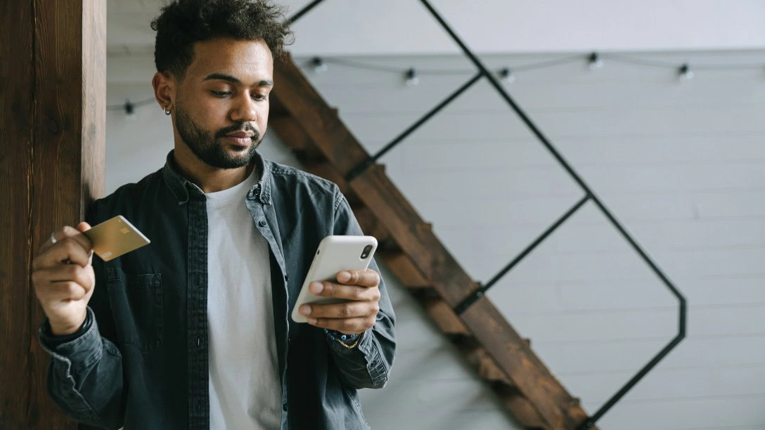 Man paying with a credit card on his cell phone