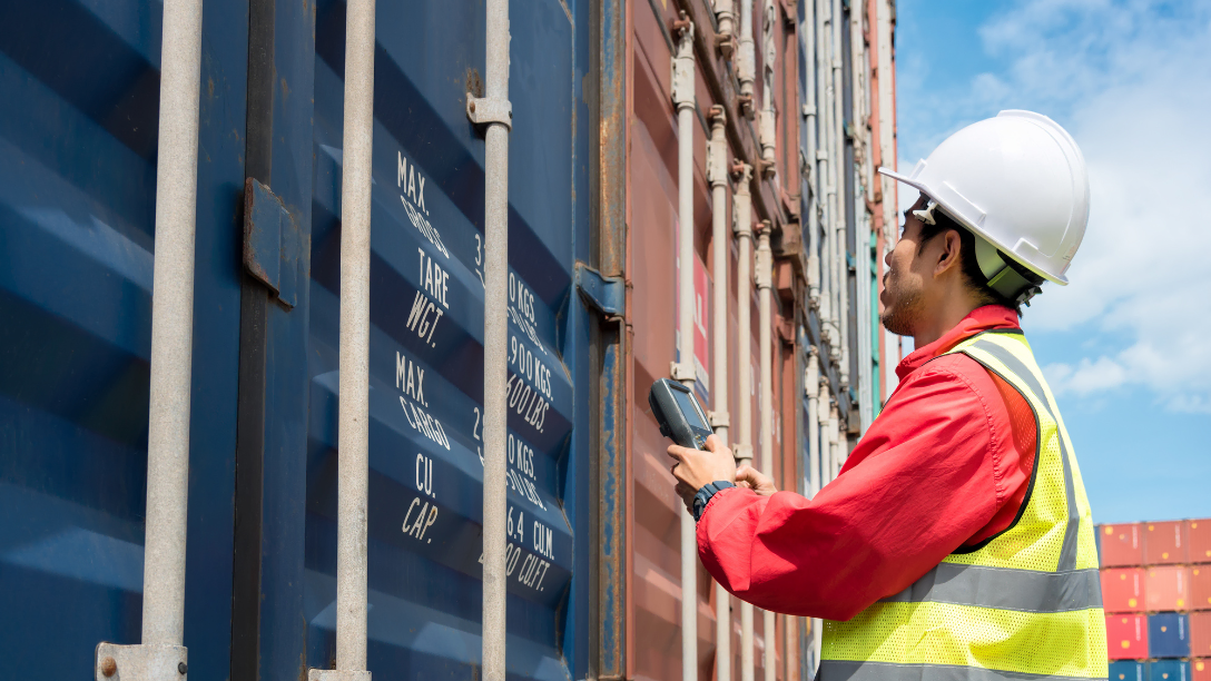 Shipping dock worker holding scanner wearing protective gear