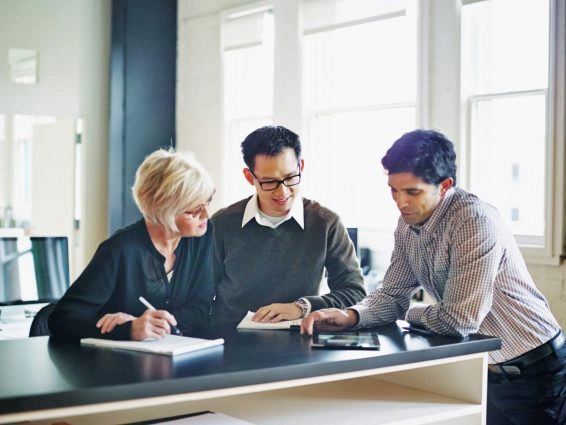Coworkers discussing project on digital tablet