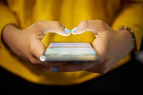 Woman typing phone message on social network at night