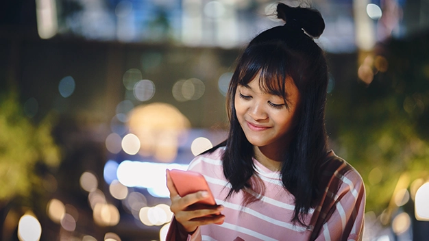 Asian young girl using a mobile phone in downtown