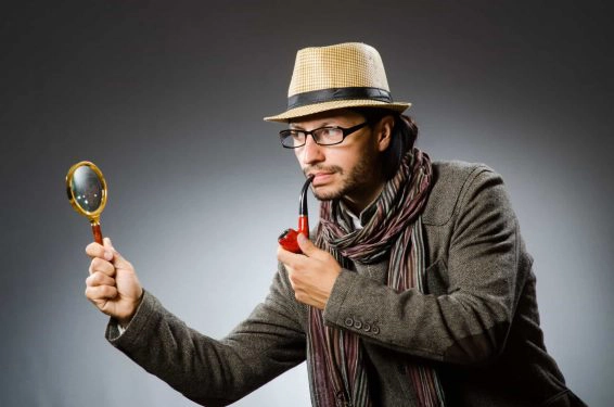 Funny detective with smoking pipe and magnifying glass