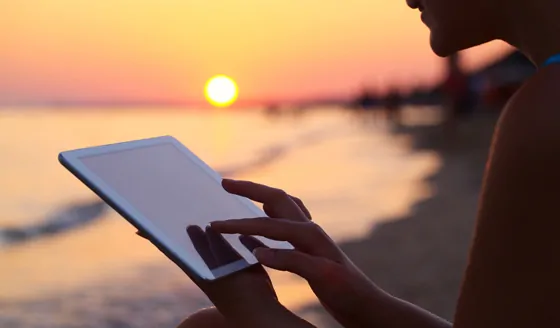 Woman with tablet at sunset