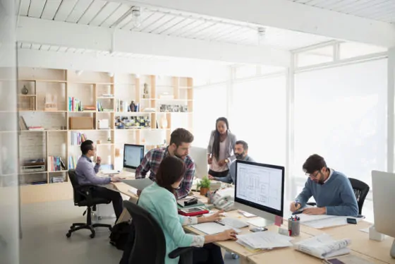 Architects working at computers in open plan office